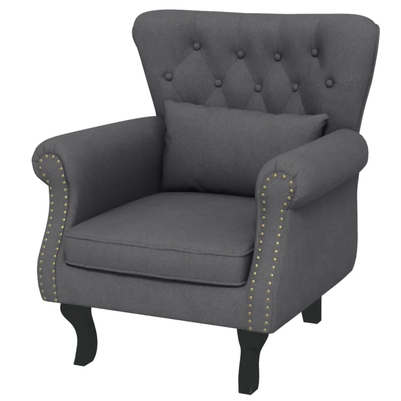 Dark grey tufted wingback armchair with pillow and wooden legs.