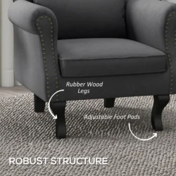 Close-up of a dark grey Chesterfield-style armchair with wooden legs.