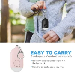 Person holding a black personal alarm with a keychain, easy to carry.