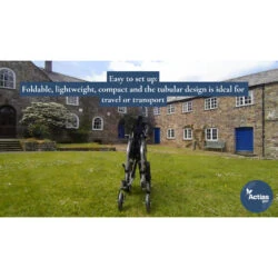 Folded aluminium wheelchair on grass with stone buildings in background.