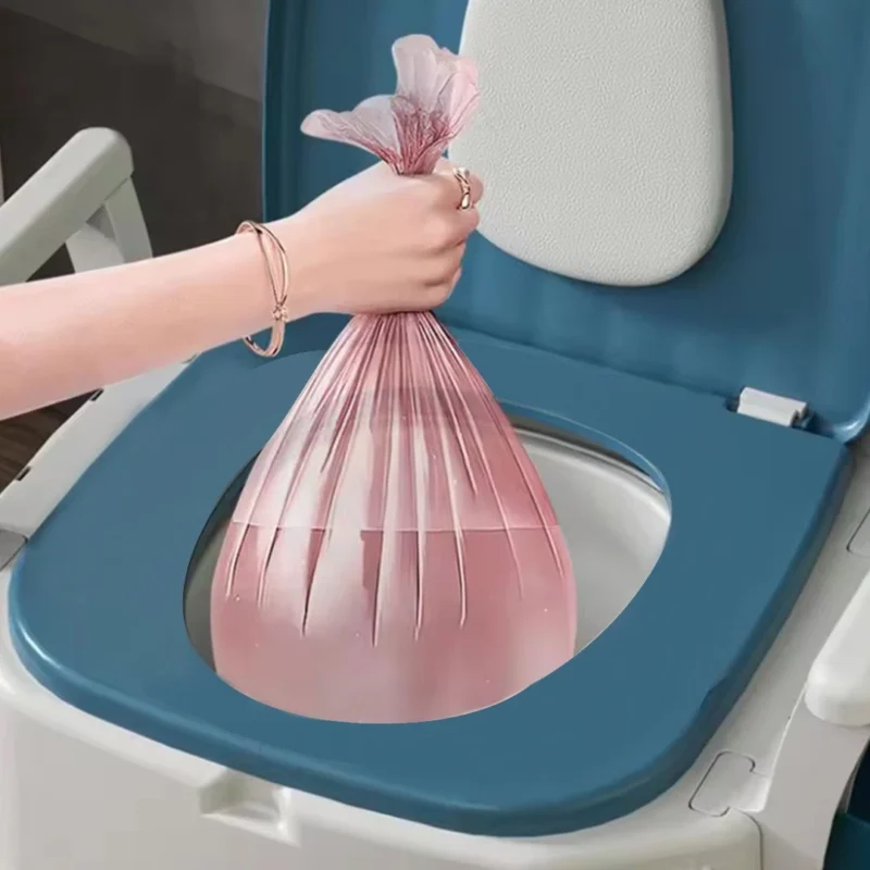 Hand holding a pink bag over a commode with a blue seat.