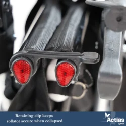 Close-up of a folded rollator with red reflectors and retaining clip.