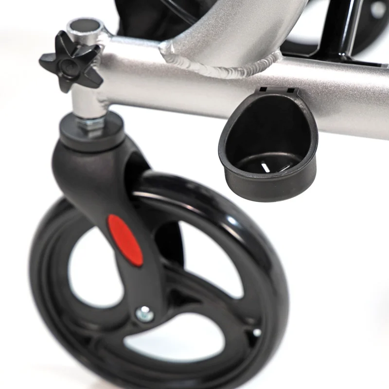 Close-up view of a rollator's black wheel and silver frame.