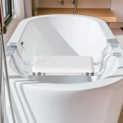 Suspended bath seat hooked over the rim of a modern white bathtub