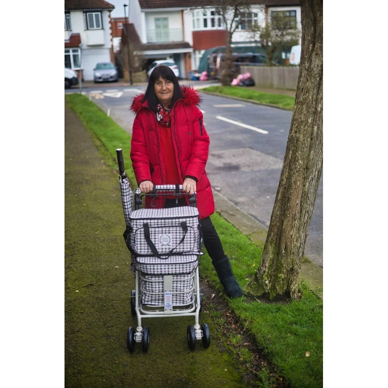 Woman walking along a pavement with the Noble shopping trolley