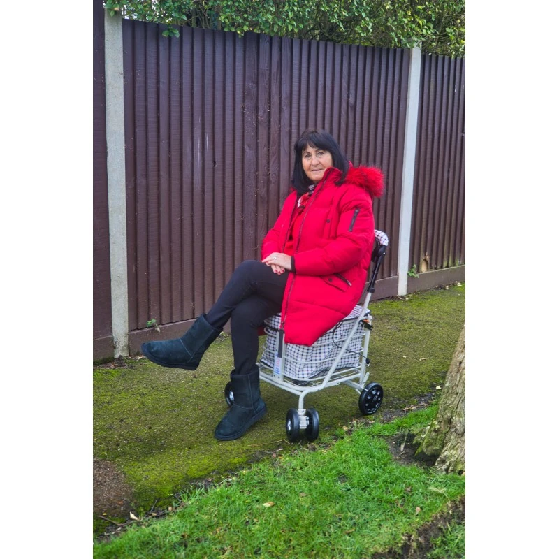 Woman resting outdoors on the Regal shopping trolley seat